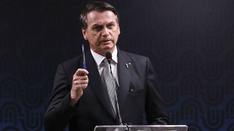 Jair Bolsonaro com caneta - demissões  como corte de cabeça de aliados